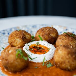 Close-up of crispy fried balls with a savory sauce