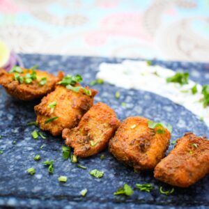 A vibrant plate of Indian fish tikka garnished with herbs
