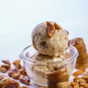 Creamy homemade fig almond ice cream scoops in a glass bowl