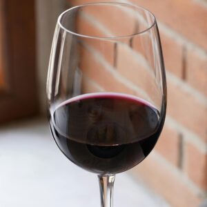 A glass of red wine on a wooden table