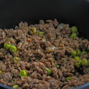 Close-up of a savory dish with minced meat and peas